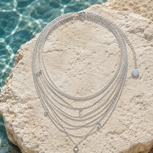 AOI silver multi-layer necklace in a natural seaside jewelry editorial