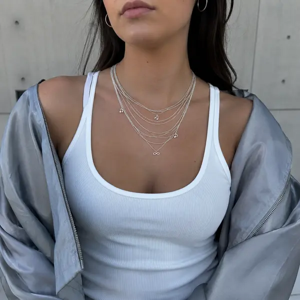 AOI layered silver necklace styled with a Gen Z streetwear look