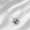 AOI dark pearl-style planet necklace arranged on pearl-white satin