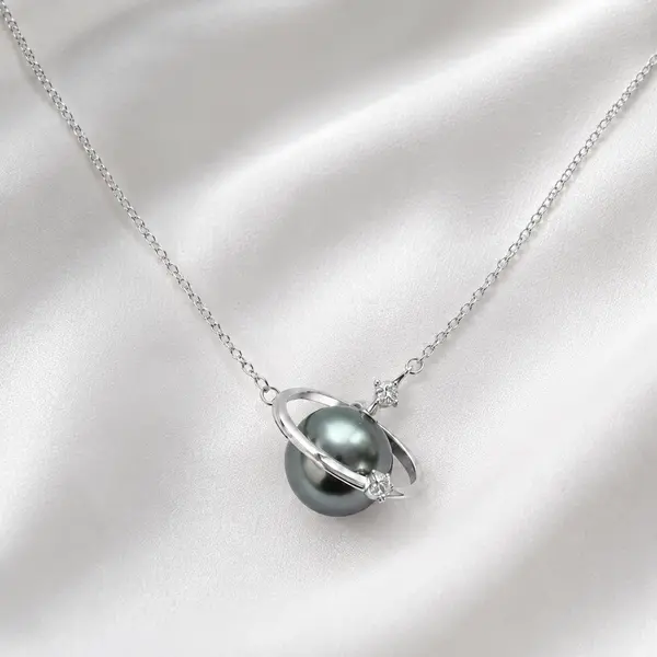 AOI dark pearl-style planet necklace arranged on pearl-white satin