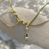 ISLA olive-green teardrop necklace in a natural coastal jewelry editorial