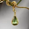 Macro detail of the olive-green teardrop accent and serpent-head connector