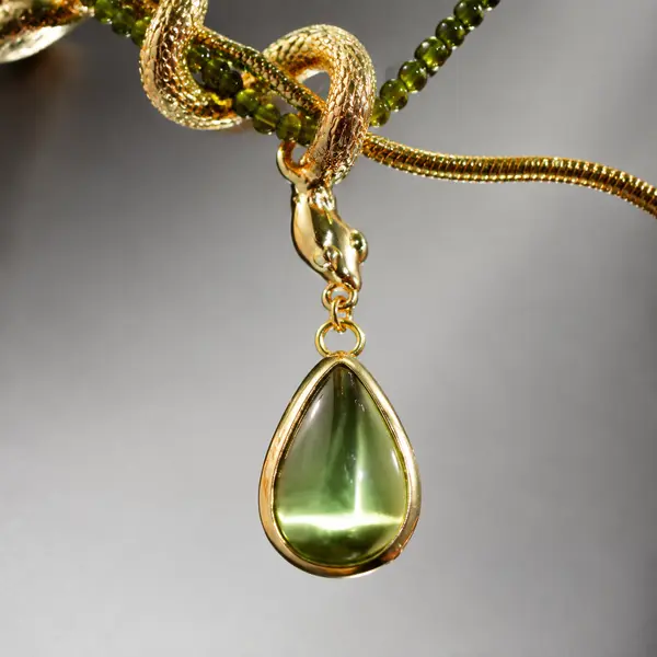 Macro detail of the olive-green teardrop accent and serpent-head connector