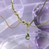 ISLA gold and olive-green serpent necklace in a refined Y3K editorial
