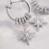 Macro jewelry detail of Celestial Starburst Hoop Earrings | Silver-Tone Pavé Drop Earrings