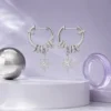 Celestial Starburst Hoop Earrings | Silver-Tone Pavé Drop Earrings in a MIRLINKS Gen Z Y3K jewelry editorial