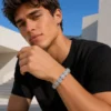 Gen Z man wearing the RHEA cushion halo bracelet outdoors